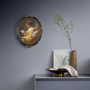 An oval-shaped black picture frame with embossed flourish details. It is designed for both wall and tabletop display.