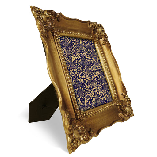Decorative gold picture frame with intricate patterns on a white background.