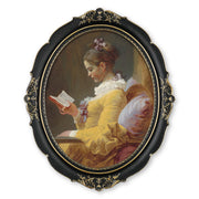 An oval-shaped black picture frame with embossed flourish details. It is designed for both wall and tabletop display.