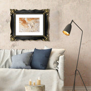 An ornate black picture frame with gold accents, displaying a mountain range artwork.