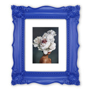 A blue picture frame with a decorative design, displaying a picture of a floral arrangement inside.