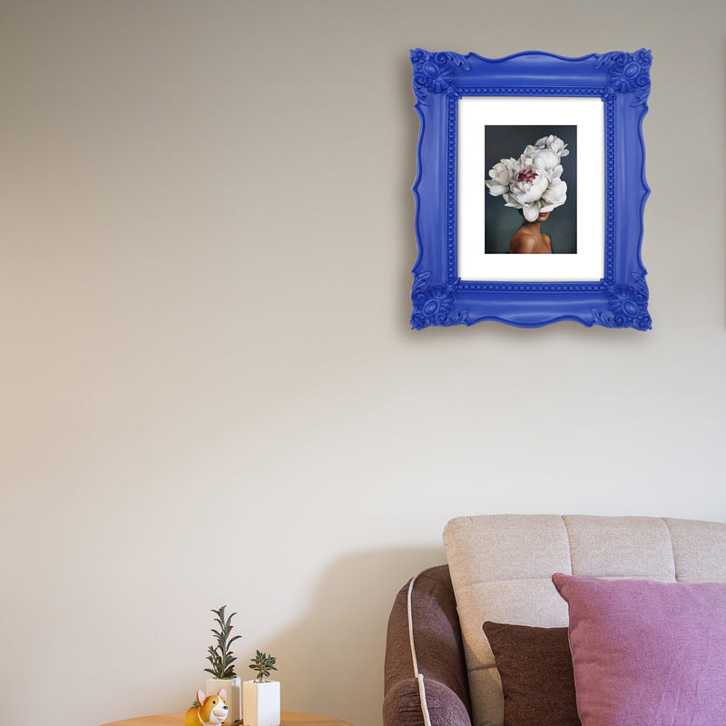 A blue picture frame with a decorative design, displaying a picture of a floral arrangement inside.
