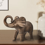 A elephant sculpture standing 6 inches tall, features a rich bronze finish with hand-painted details that highlight its artistry.