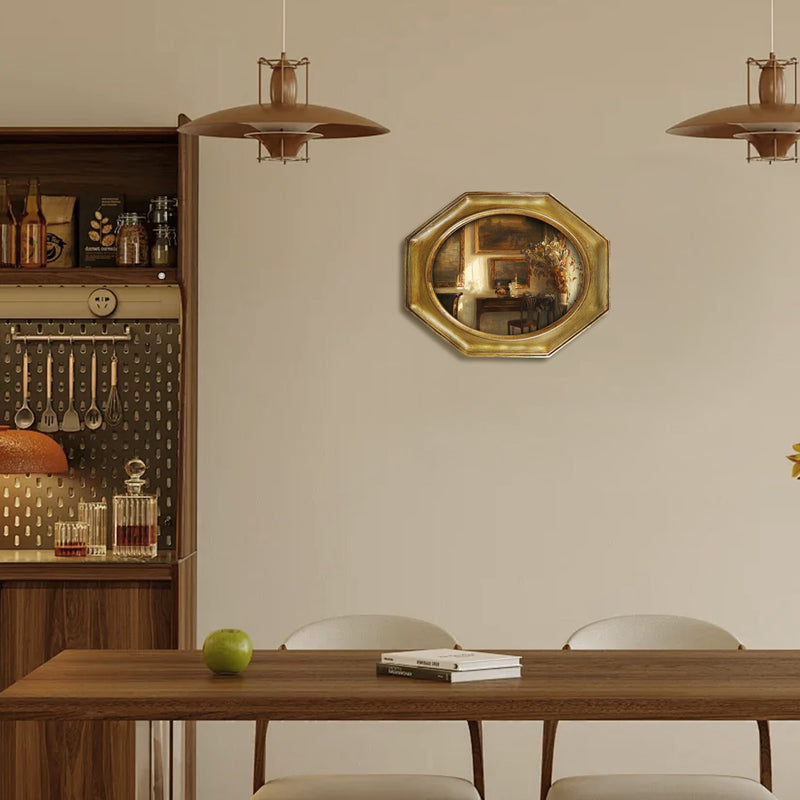 An antique-style octagon picture frame with a brushed gold finish is displayed on a wall.