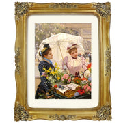 Decorative gold frame with a painting of two women under an umbrella.