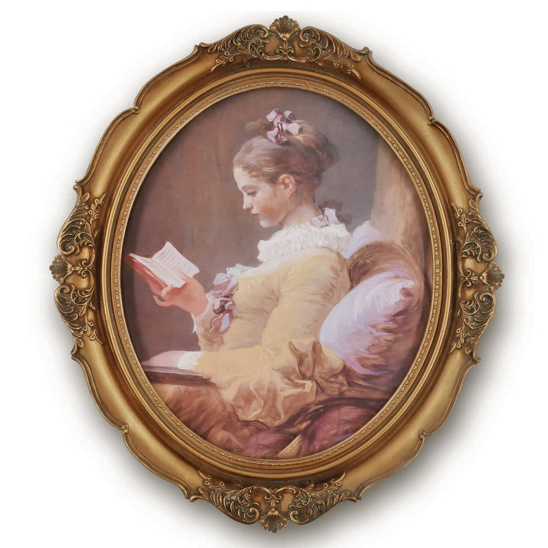 An oval-shaped, gold-colored picture frame with embossed details, containing a framed artwork of a person reading.