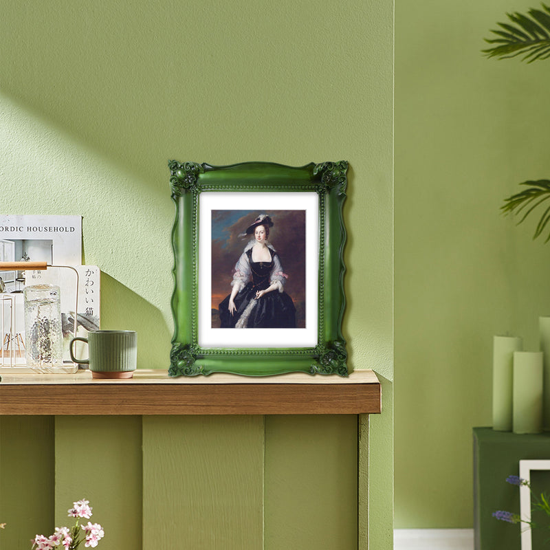 An ornate green picture frame with floral carvings around the border, designed for an 11x14 poster.