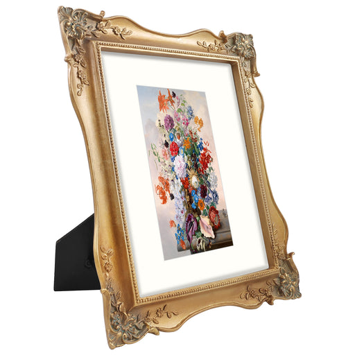 An 8x10 picture frame with floral corner ornaments, designed for tabletop and wall display, made of resin and painted to achieve a vintage look.