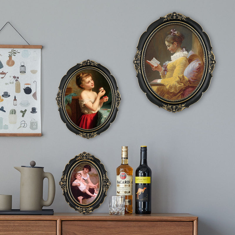 An oval-shaped black picture frame with embossed flourish details. It is designed for both wall and tabletop display.