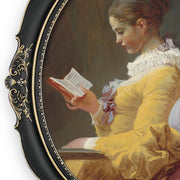 An oval-shaped black picture frame with embossed flourish details. It is designed for both wall and tabletop display.