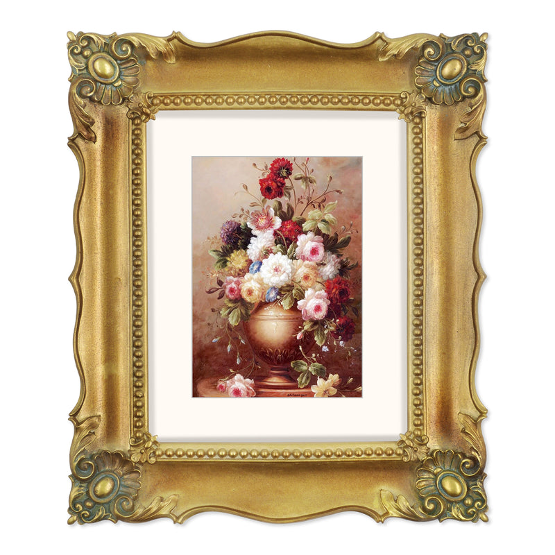 A bronze picture frame with a decorative design, displaying a picture of a floral arrangement inside.