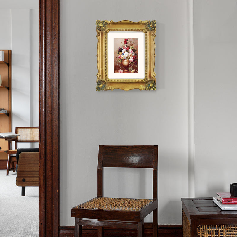 A vintage bronze picture frame with a decorative design, displaying a picture of a floral arrangement inside.