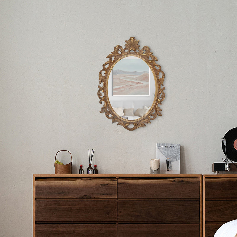 A vintage oval wall mirror with a decorative gold frame, designed for mounting on a wall.