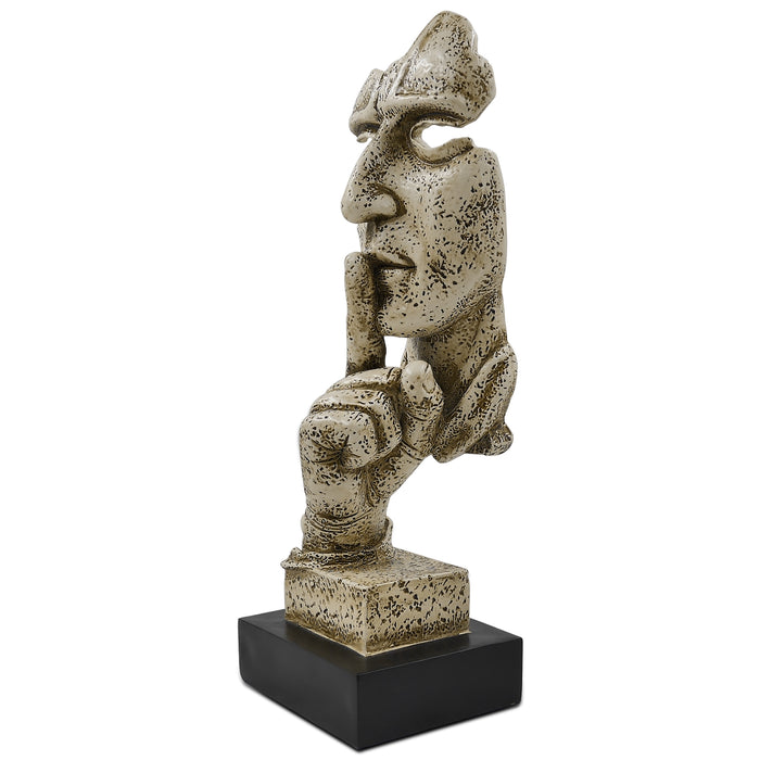 A sculpture of a human figure with an index finger to their lips, indicating silence or quiet. The figure appears to be made of a textured, possibly stone or concrete-like material, and is placed on a dark base.