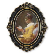 An oval-shaped black picture frame with embossed flourish details. It is designed for both wall and tabletop display.