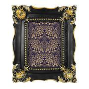 Decorative picture frame with black and gold design.