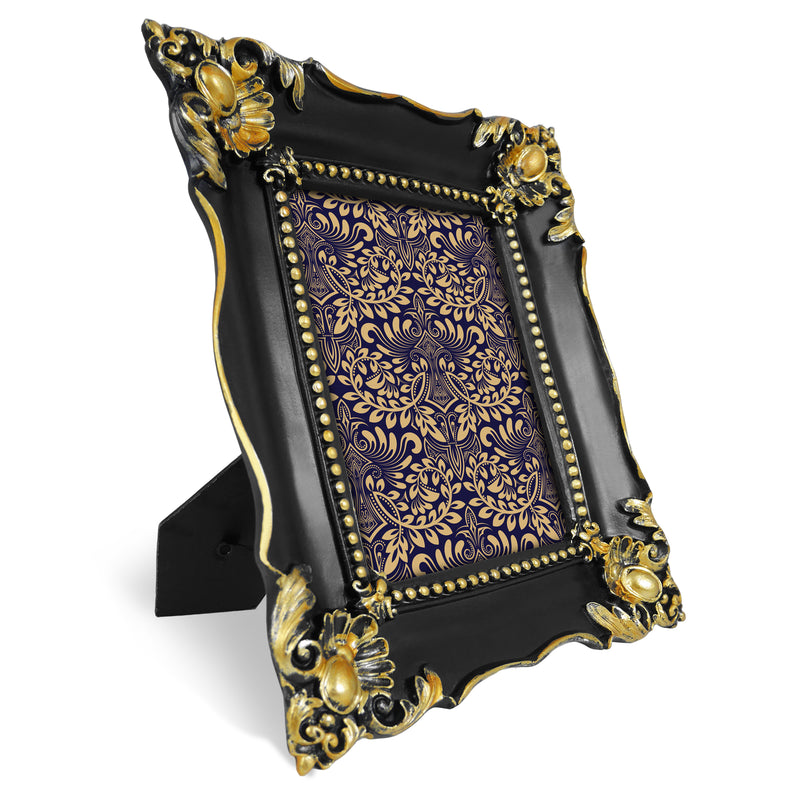 Decorative black and gold picture frame with intricate patterns on a white background.