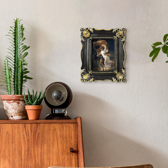 Decorative black frame with a dog portrait on a wall above a wooden cabinet with plants.