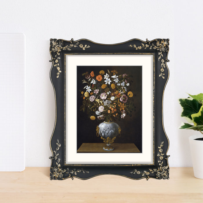 Framed artwork of a still life with flowers on a wooden surface.