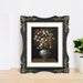 Framed artwork of a still life with flowers on a wooden surface.