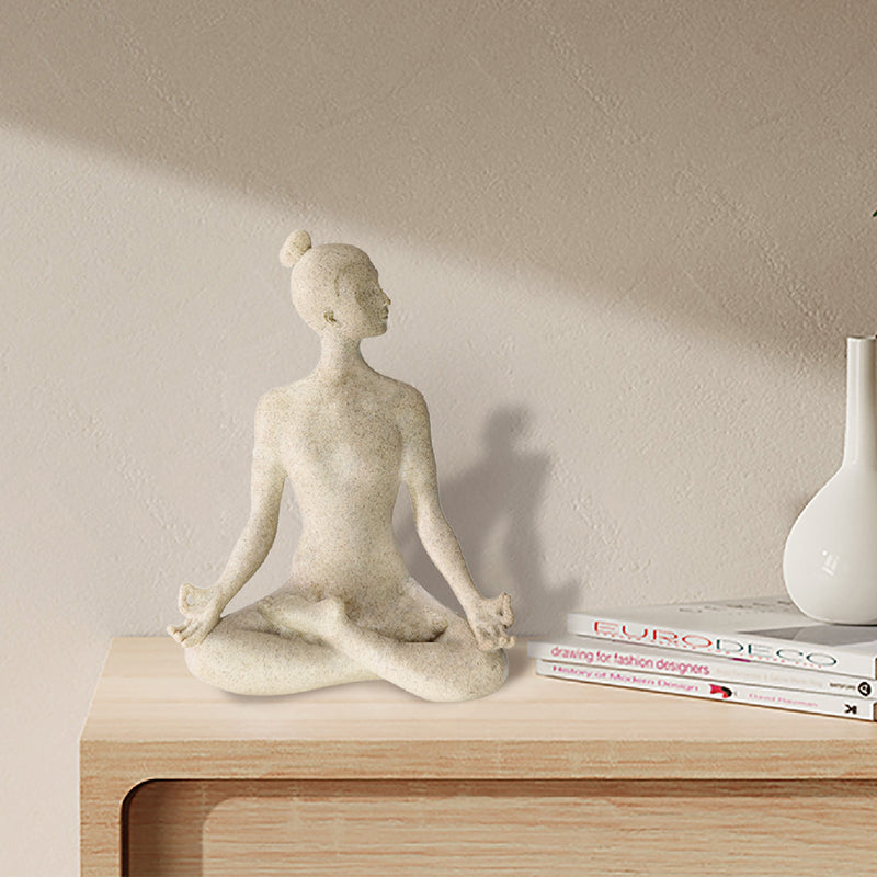 A beige yoga lady statue in a meditation pose, 9.5 inches tall, with a textured surface resembling sandstone.