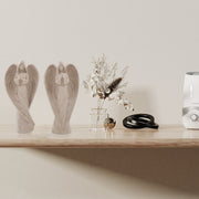 Decorative items including angel statues, a vase with flowers, and a humidifier on a wooden shelf.