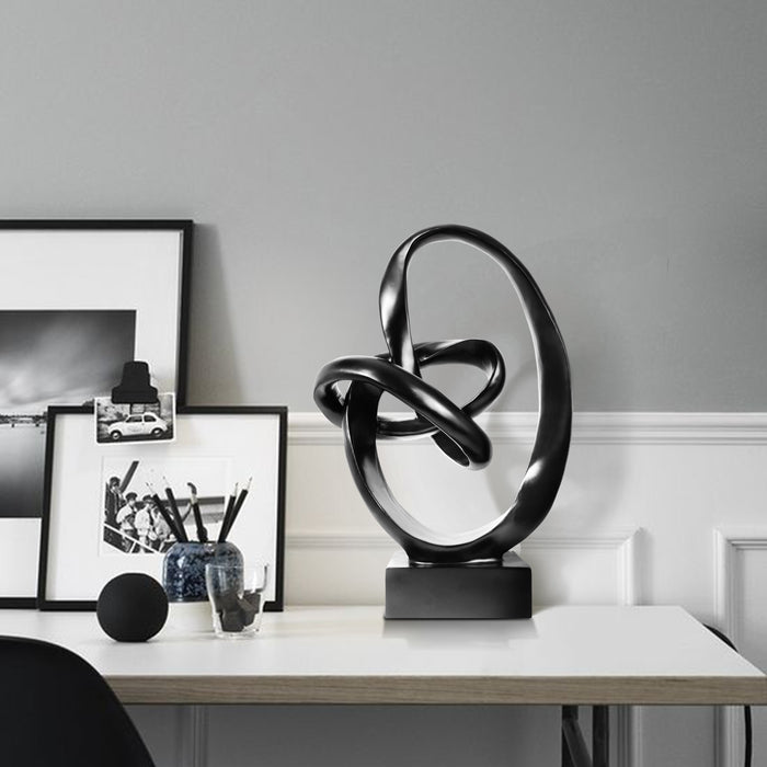Black abstract sculpture on a white background.