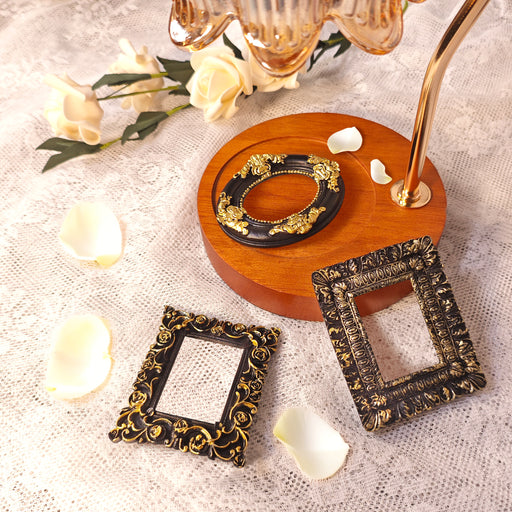 Decorative picture frames with gold accents on a textured surface with flowers.