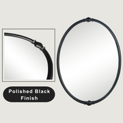 An oval-shaped mirror with a traditional frame in a bathroom setting, reflecting a modern shower stall and bathroom decor.