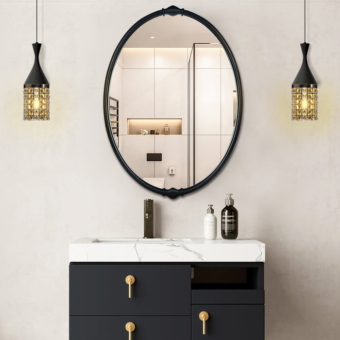 An oval-shaped mirror with a traditional frame in a bathroom setting, reflecting a modern shower stall and bathroom decor.