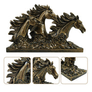 A bronze sculpture of three horses in mid-gallop with flowing manes, positioned on a flat base.
