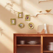 Decorative wall with framed pictures and a wooden cabinet with glass doors.