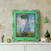 An ornate vintage-inspired picture frame with green edges and gold accents, designed for an 8x10-inch picture, featuring a decorative painting of a woman inside.