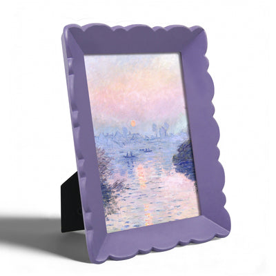Purple scalloped frame with a painting of a sunset over water on a white background