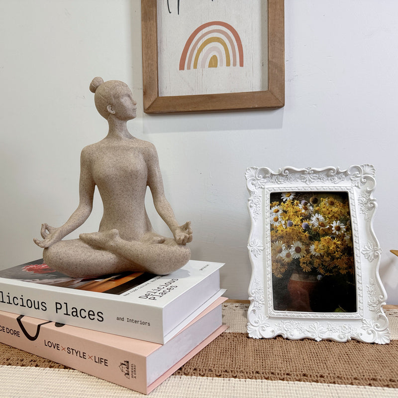 A beige yoga lady statue in a meditation pose, 9.5 inches tall, with a textured surface resembling sandstone.
