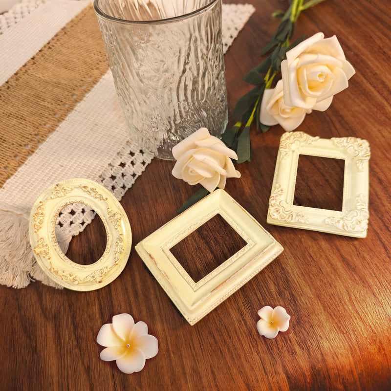 Decorative picture frames and flowers on a wooden surface