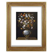 A vintage style picture frame with a floral design on the corners and a beaded border, displaying an 11x14 picture of a vase with flowers.