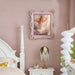 An ornate vintage-inspired picture frame with pink edges and gold accents, designed for an 8x10-inch picture, featuring a decorative painting of a woman inside.