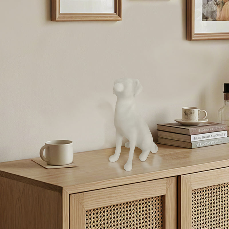 White dog sculpture on a wooden cabinet with books and mugs in a room.