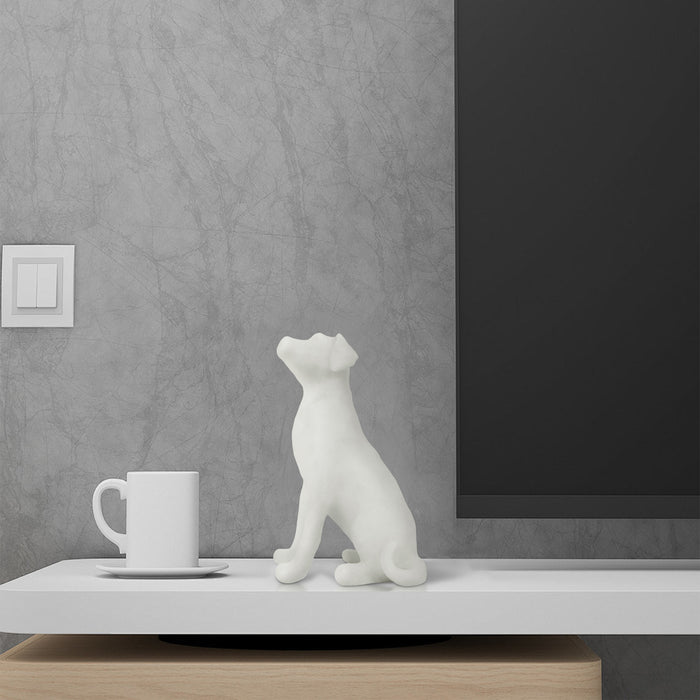 White marble dog figurine and white mug on a wooden surface with gray wall background.