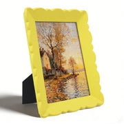 Yellow photo frame with a scenic painting inside on a white background