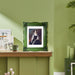 An ornate green picture frame with floral carvings around the border, designed for an 11x14 poster.