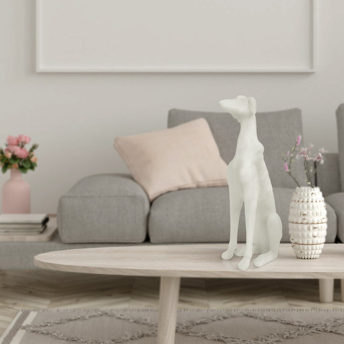 White dog sculpture on a coffee table in a living room setting with a sofa and decorative items.