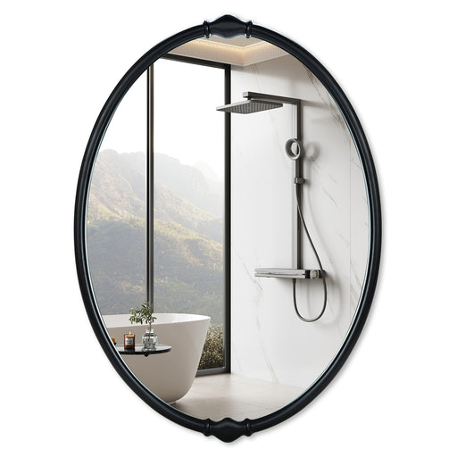 An oval-shaped mirror with a traditional frame in a bathroom setting, reflecting a modern shower stall and bathroom decor.