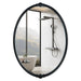 An oval-shaped mirror with a traditional frame in a bathroom setting, reflecting a modern shower stall and bathroom decor.
