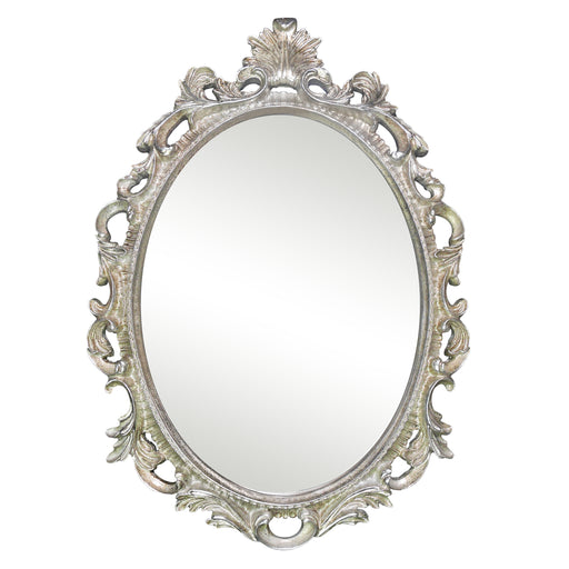 An oval mirror with a scroll design in an antique silver finish, reflecting a well-lit interior room.