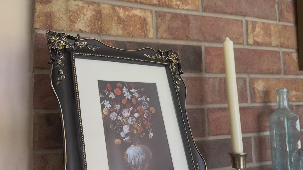 Video of decorative black picture frame with floral design.