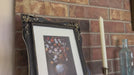 Video of decorative black picture frame with floral design.