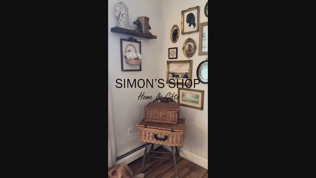 An oval-shaped, gold-colored picture frame with embossed details, containing a framed artwork of a brown horse.