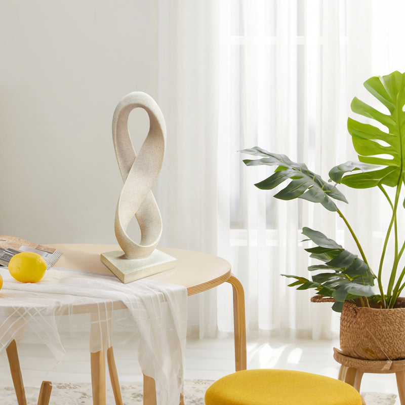 Decorative sculpture on a table with a plant in the background.